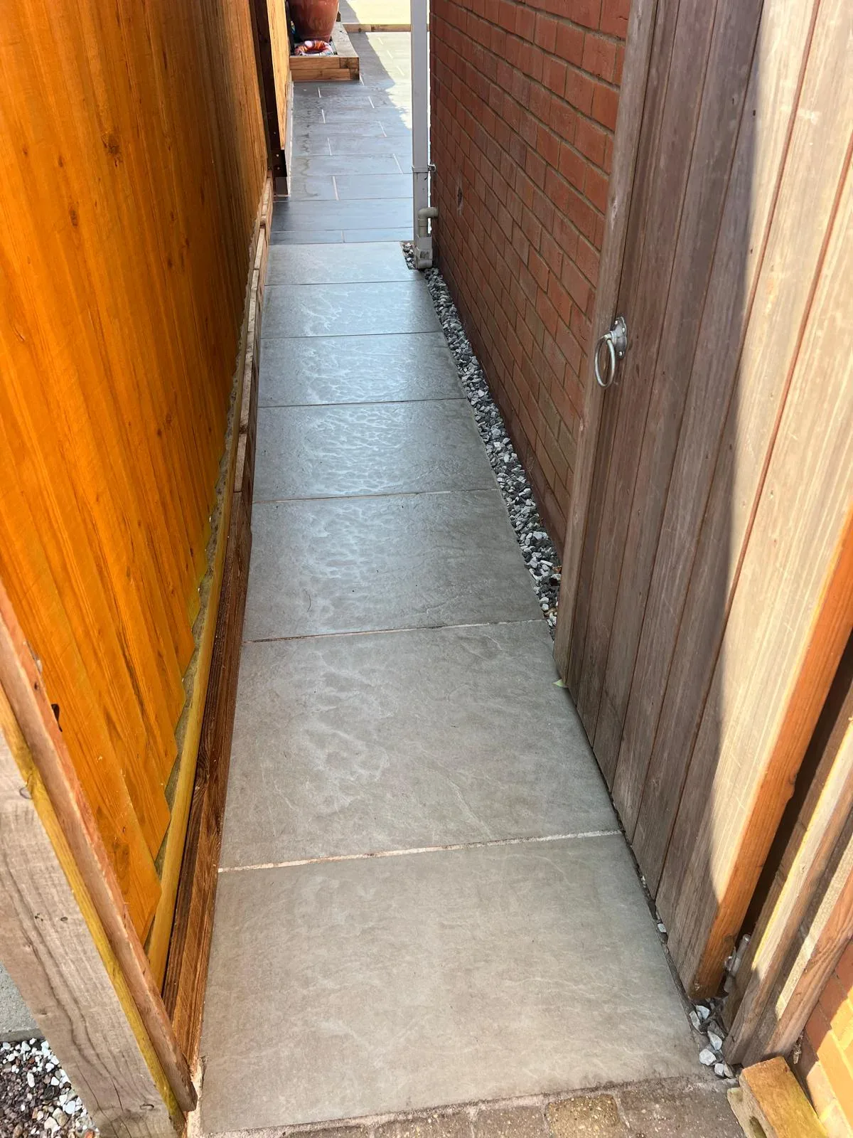 New paved side passage between the house and timber boundary