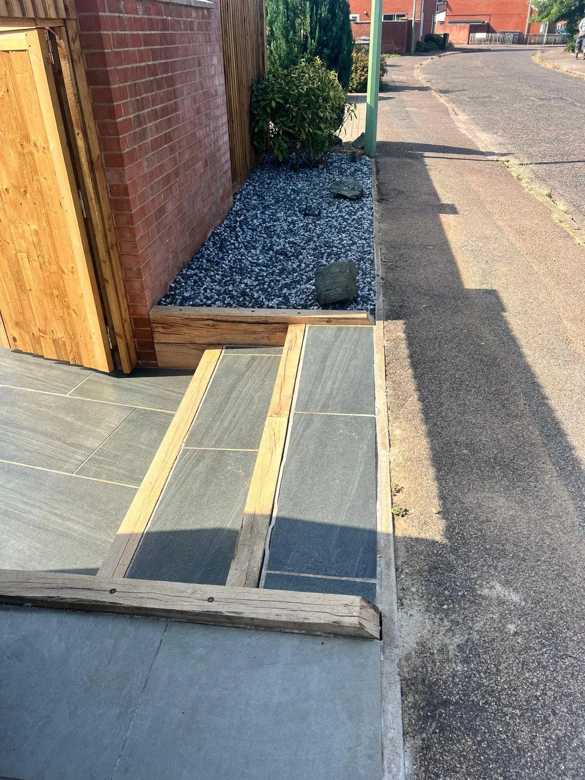 Porcelain steps and timber-edged access leading to the pavement