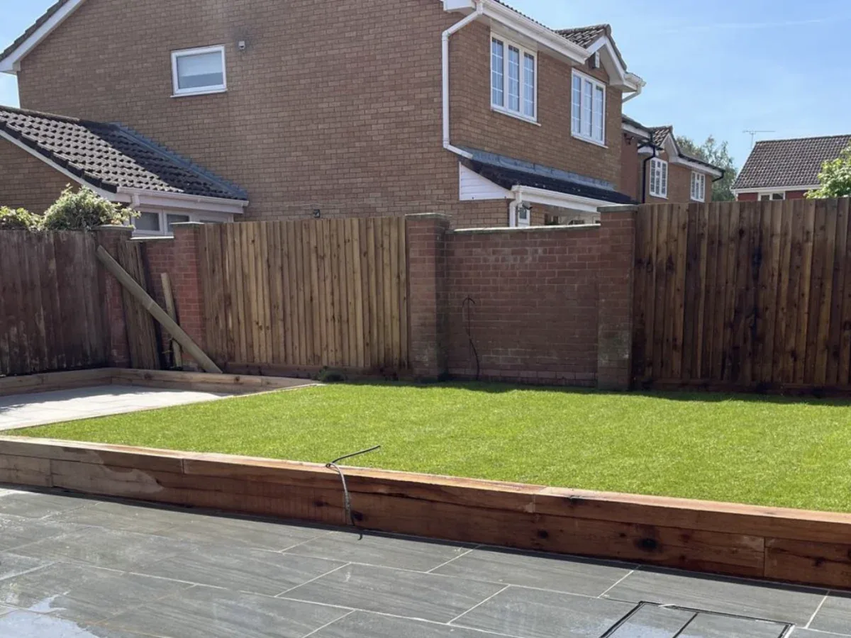 Completed LB Services garden with porcelain paving and a raised lawn