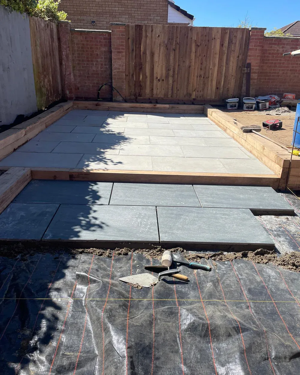 Porcelain paving being laid across the new tiered garden layout