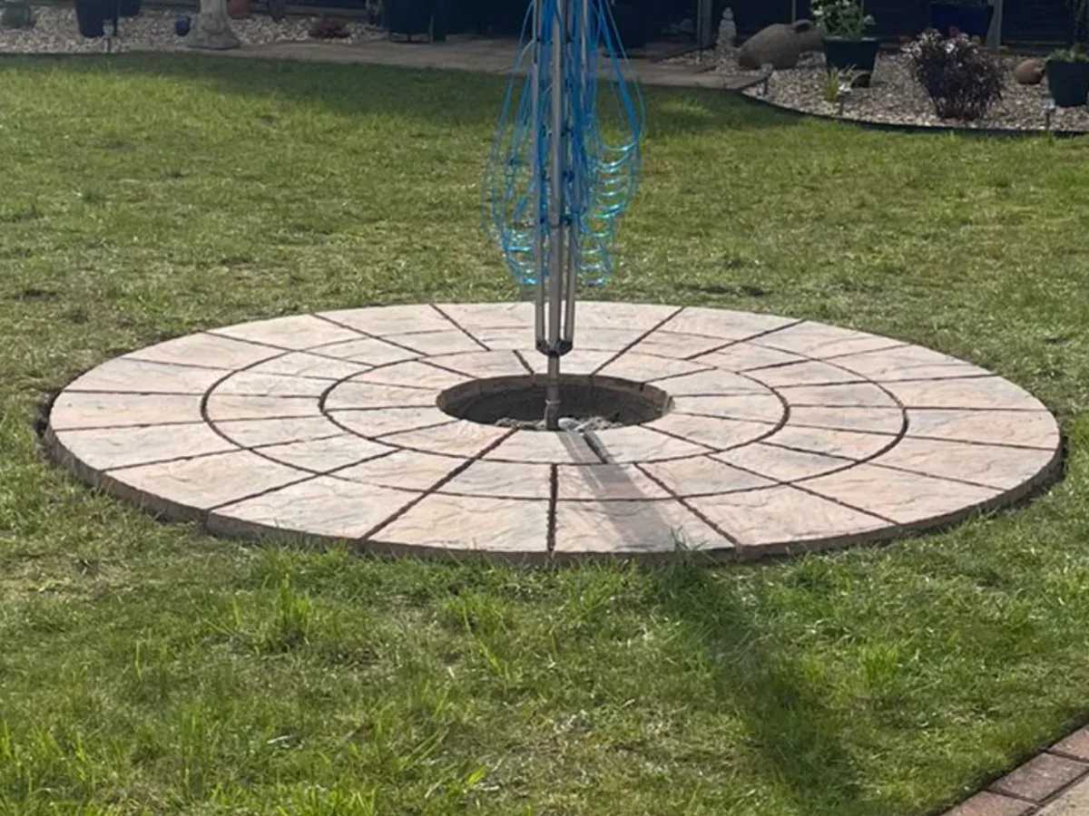 Completed circular paved feature set into a garden lawn